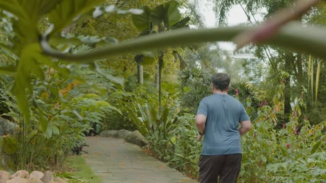 Un-Hombre-Malayo-Asiático-Gordo-Corriendo-Por-Su-Salud-En-El-Jardín-Del-Lago,-Con-Un-Tiro-Amplio-Hacia-Atrás