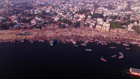 crowded buildings with ganga river and boats at banaras ghat road kashi, varanasi, uttar pradesh, india. day time, stable shot, drone shot, 4k.