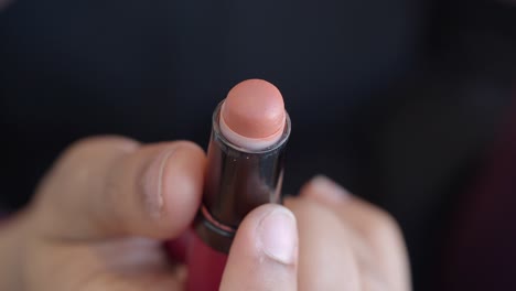 close up of a person holding a lipstick