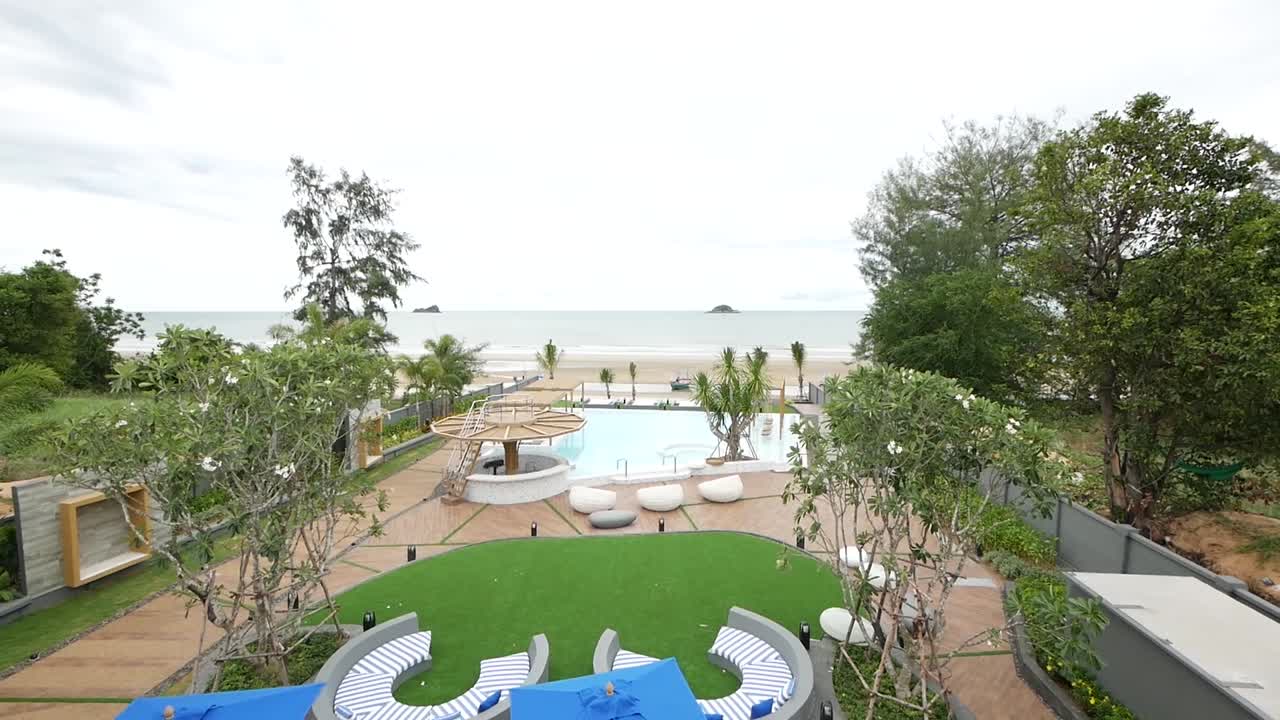 아름다운 해변 전망으로 둘러싸인 수영장이 있는 편안한 정원