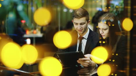 A-couple-in-love-rests-in-a-cafe-and-uses-a-tablet