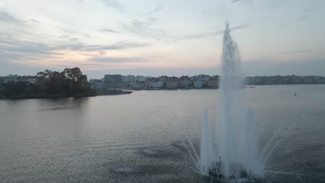 footage of the beautiful fountain standing in the middle of the water in the naval city of karlskrona, sweden on a cloudy day when the sun is about to set-1