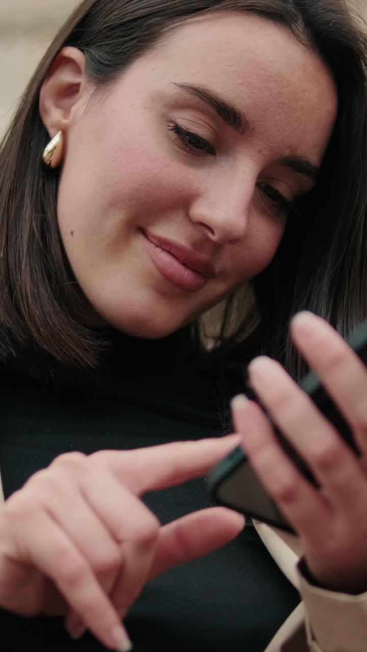 Giovane donna sorridente che scorre il suo smartphone
