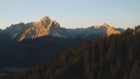 Epic-Aerial-drone-shot-of-beautiful-lights-of-sunrise-illuminating-Sesto-Dolomites-during-summer-day---South-Tyrol,Italy