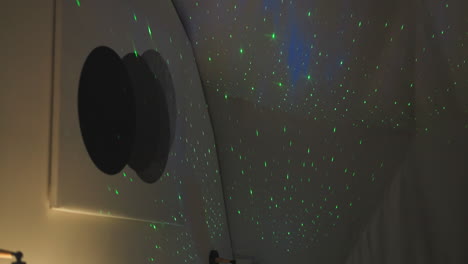 starry sky light imitation by projector in bedroom. spellbound green lights on white semi-spherical wall of glamping house. fairy tale home device