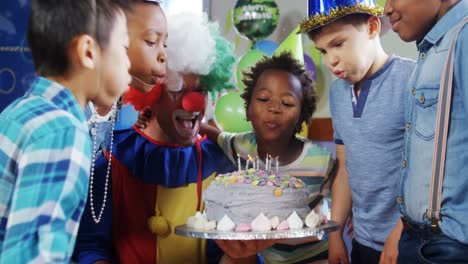 Niños-Con-Payaso-Soplando-Velas-En-El-Pastel-Durante-La-Fiesta-De-Cumpleaños-4k