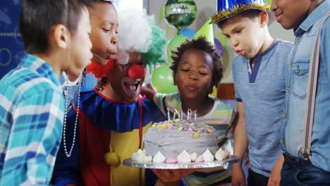 kids with clown blowing candles on cake during birthday party 4k