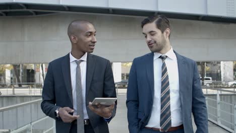 hombres de negocios sonrientes con tabletas digitales