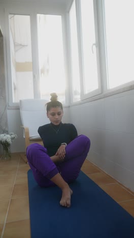 mujer practicando yoga en un balcón