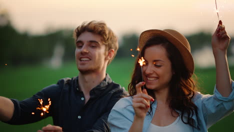 Feliz-Pareja-Bailando-Con-Bengalas-En-El-Parque-De-Verano.-Gente-Emocionada-Disfruta-De-La-Fiesta