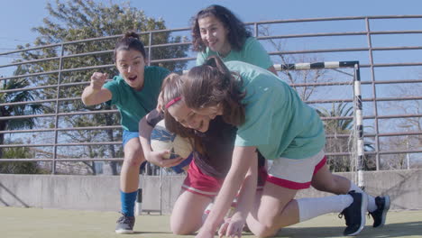 excited teenaged girl holding football and expressing happiness