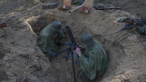 world war ii soldiers operating a mortar in a trench