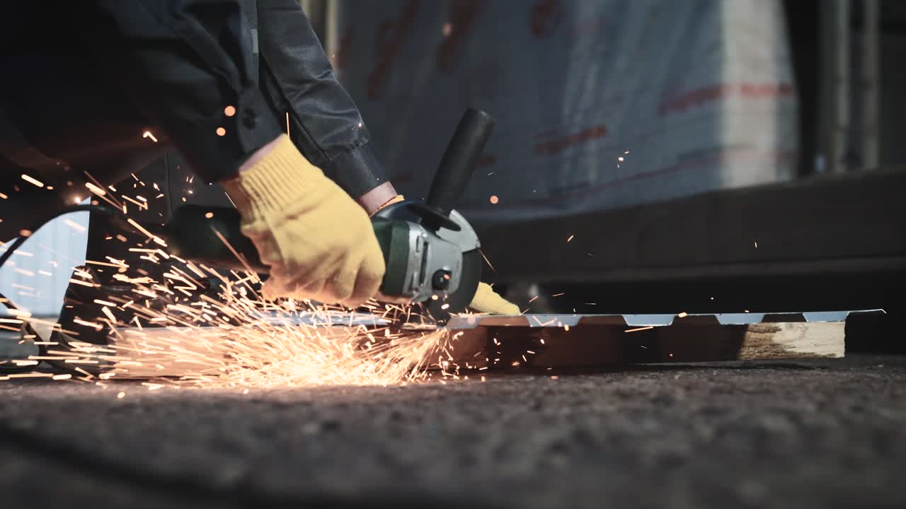 trabajador de producción. un hombre corta una hoja de metal con una molienda