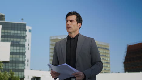 Businessman-reading-documents-on-street