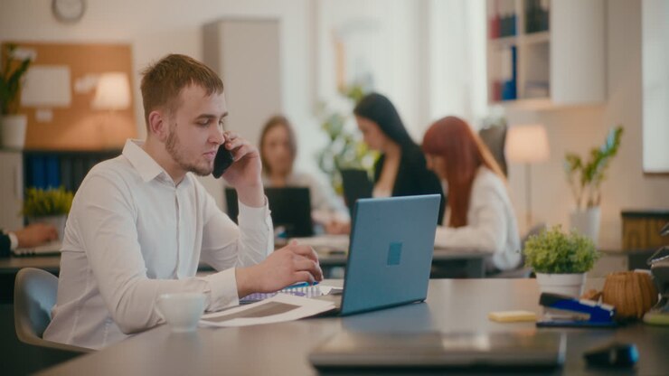 мужчина-менеджер разговаривает по мобильному в офисе.