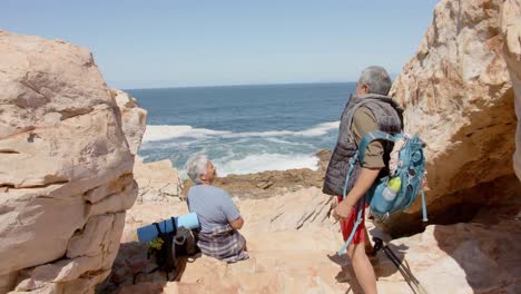 una feliz pareja biracial en las montañas descansando en el mar, en cámara lenta