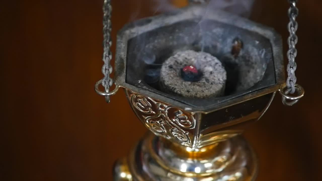 dispositivo de fumar en medio del ritual. primer plano en cámara lenta de un dispositivo de fumar en el medio del ritual en el medio de la iglesia
