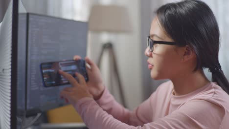 woman coding and taking a photo of code on mobile