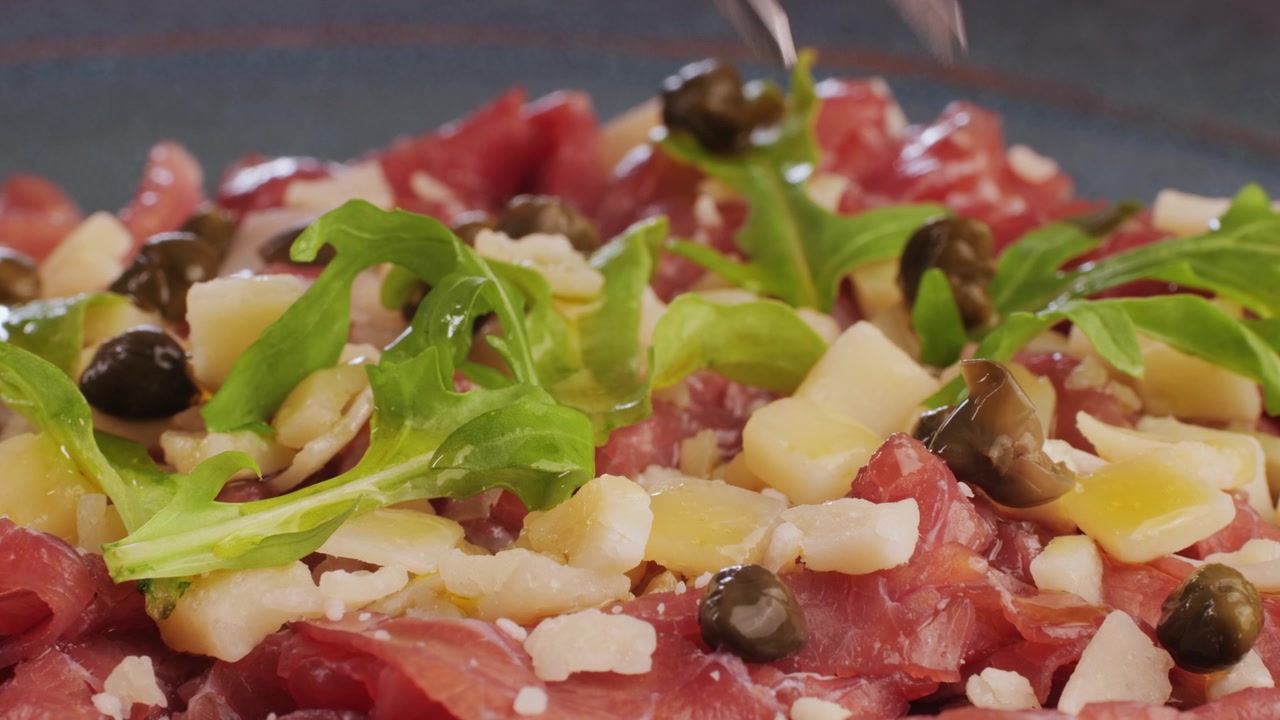 Guarnizione di carpaccio di manzo gourmet con capperi e rucola.