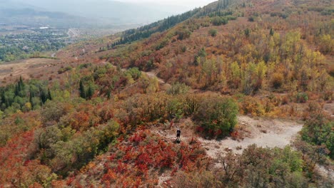 Descending-Aerial-drone-footage-of-a-Caucasian-man-on-Emerald-Mountain-in-Steamboat-Springs,-Colorado