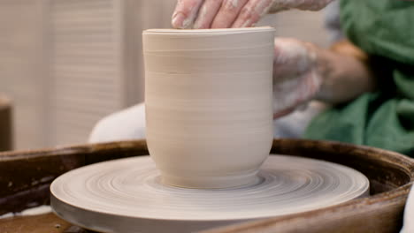 close up view of hands of a clerk modeling ceramic piece on a potter wheel in a workshop 2