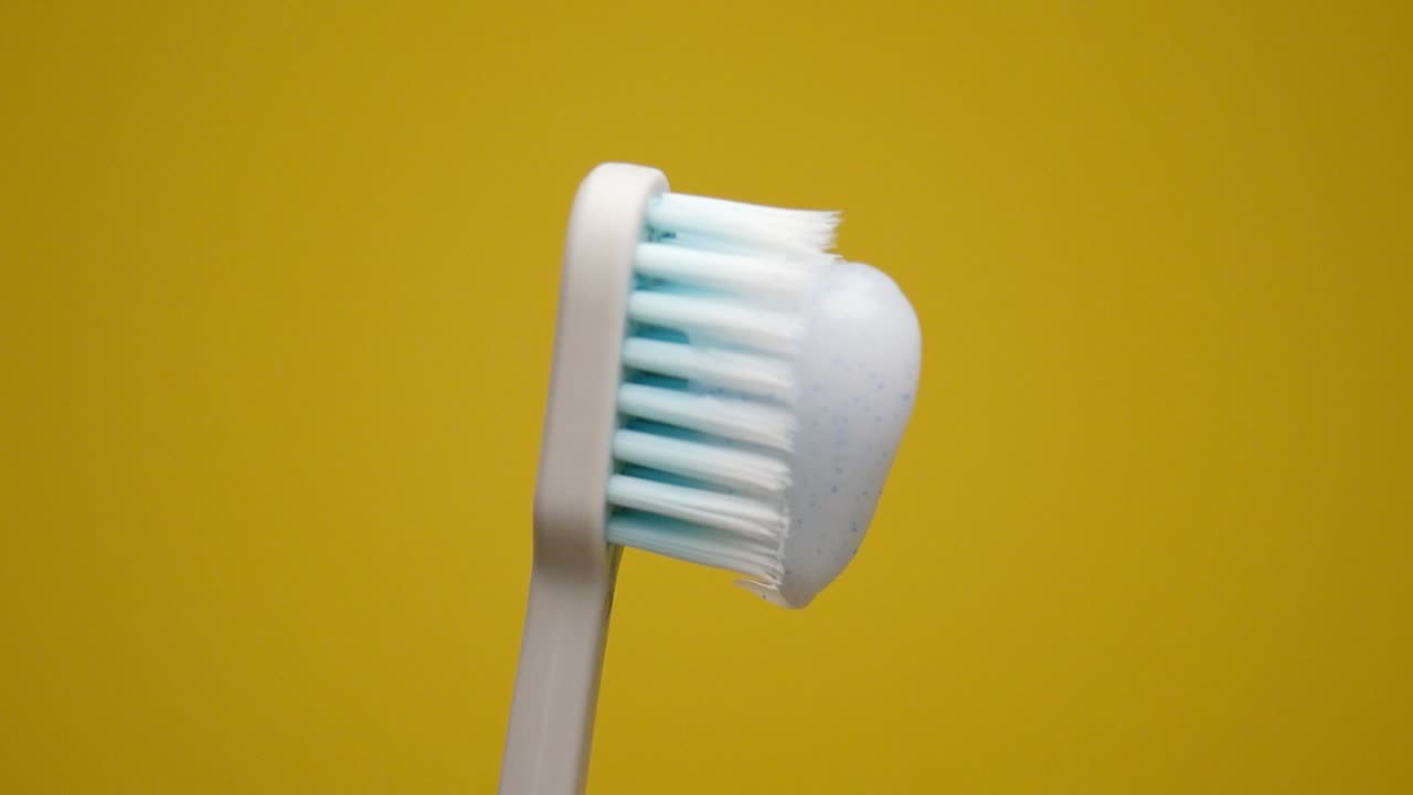 Toothbrush with toothpaste on yellow background