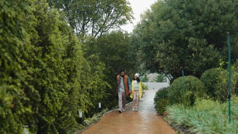 a father and daughter walking hand in hand down a path in the rain.