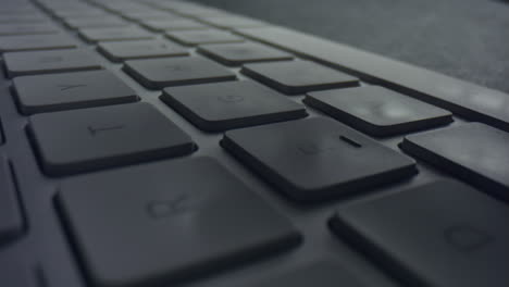 macro of male fingers pressing white keys on computer keyboard