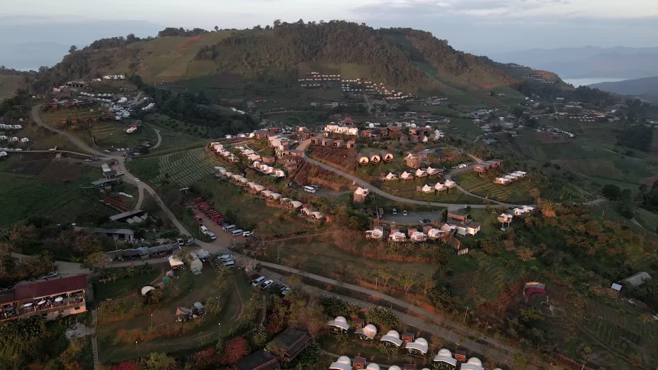 Sunrise orbit drone shot above the camp village in Thailand