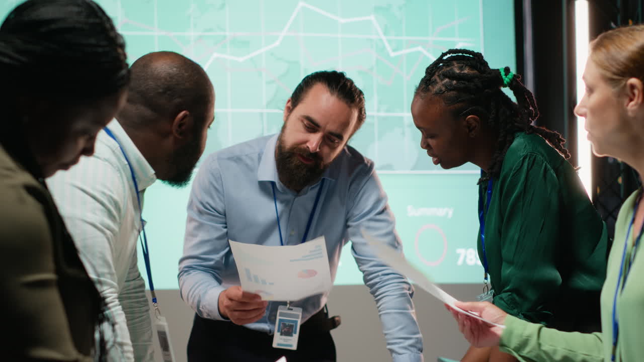 Diverse coworkers attend an after hours business meeting for analysis on files