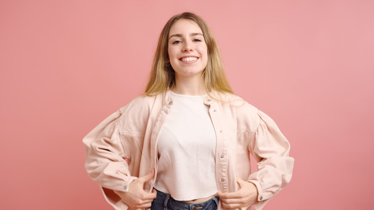 Young woman posing and smiling on pink background