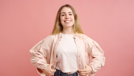 young woman posing and smiling on pink background