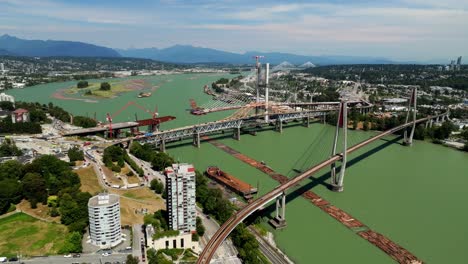 the pattullo bridge replacement is progressing across the fraser river in new westminster, vancouver, british columbia, canada - orbit drone shot