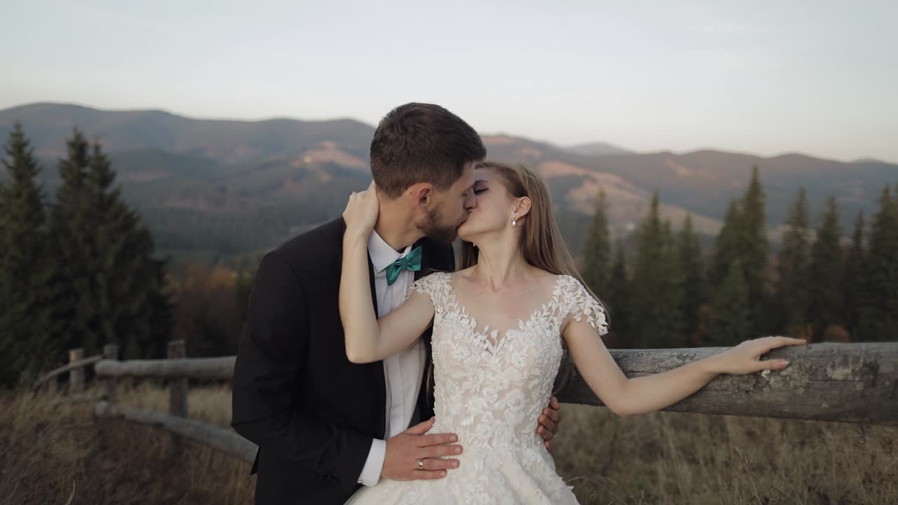 Novelli sposi. Sposo caucasico con sposa su un pendio di montagna. Coppia di sposi felici.