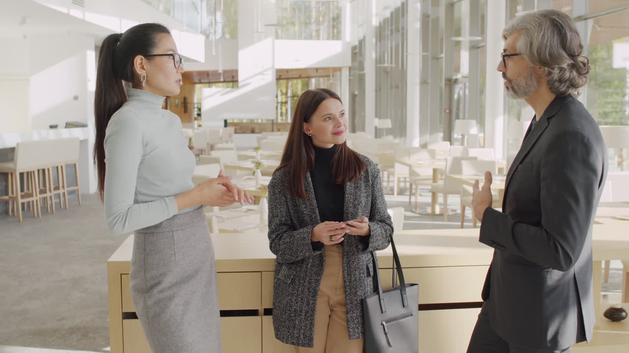 Three professionals having a discussion in a modern business lounge