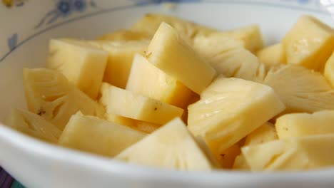 primer plano de piña cortada en cubos en un cuenco