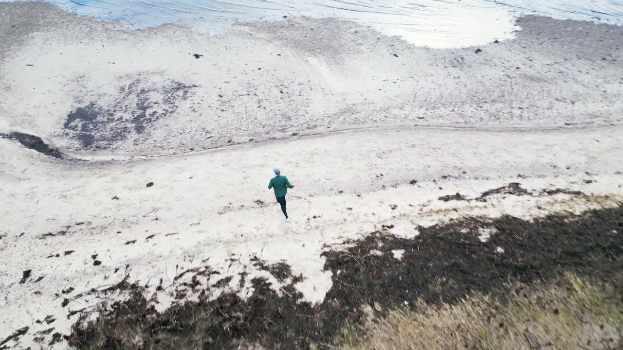 Jogger on a rural trail in an aerial countryside view near the beach on an overcast day