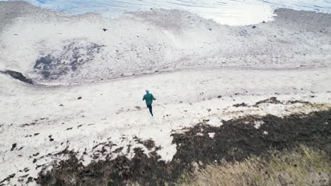 jogger on a rural trail in an aerial countryside view near the beach on an overcast day