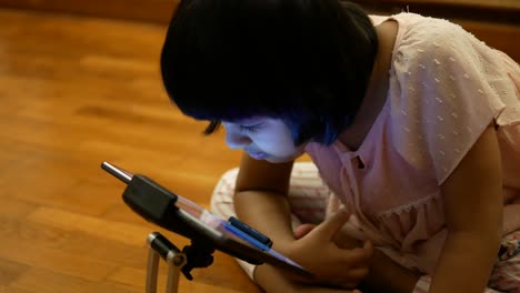 girl using tablet on floor