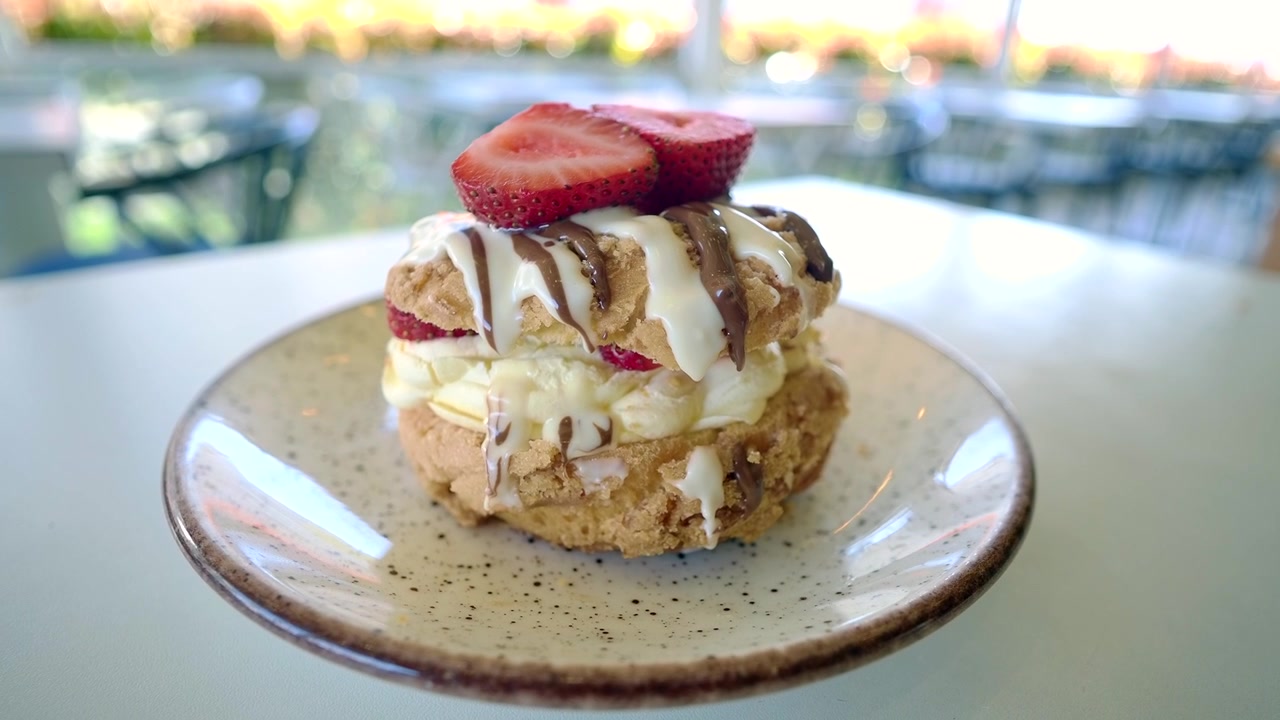 Delizioso bignè guarnito con fragole fresche e glassa al cioccolato.
