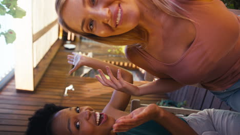 Vertical-Video-POV-Shot-Of--Female-Friends-Outdoors-At-Home-Making-Video-Call-On--Mobile-Phone