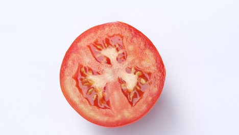 el tomate gira sobre un fondo blanco.