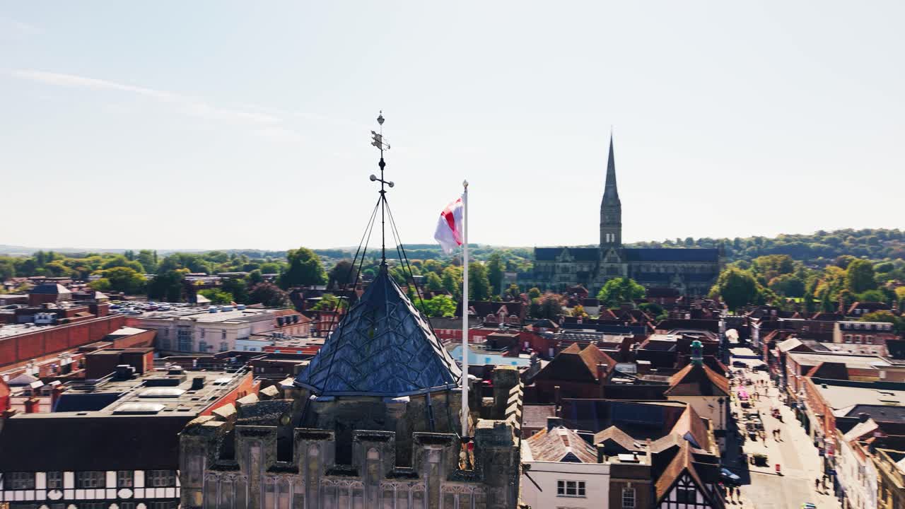 Droneutsikt over historiske tak og kirketårn i Salisbury, Wiltshire, England, med Salisbury Cathedral synlig i det fjerne.