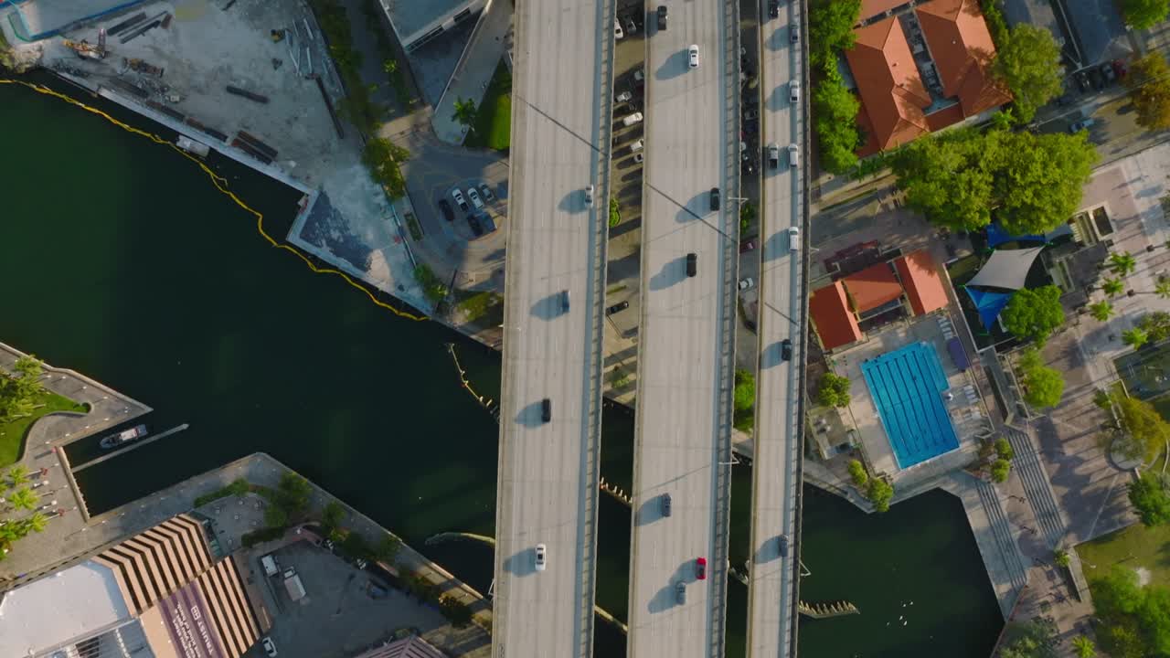 vehículos que conducen por una carretera elevada por encima de la ciudad, puente de varios carriles sobre el río miami. vista a vista de pájaros en la hora dorada. miami, ee.
