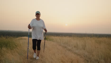 an elderly woman with nordic walking sticks walks forward through a scenic spot 2