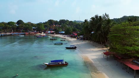 Ambiente-Matutino-Maravillosa-Vista-Aérea-Rampa-De-Velocidad-De-Vuelo-De-Una-Isla-Tropical-Con-Un-Largo-Muelle-De-Madera-Que-Conduce-A-Un-Restaurante-Flotante,-Rodeado-De-Aguas-Turquesas-Y-Una-Exuberante-Selva-Tropical