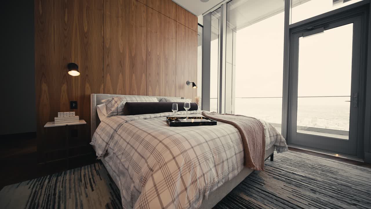 ampia spinta in una foto di una camera da letto con grandi finestre e parete di legno dietro il letto