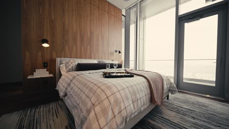 wide push in shot of a bedroom with large windows and wood wall behind the bed