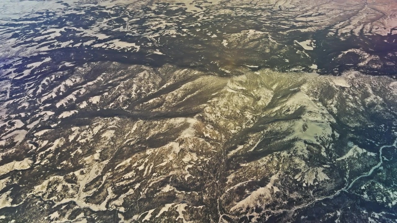 高高度から見た、ごつごつした山々の褶曲と深く浸食された地形の空撮映像