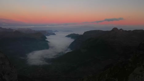 Toma-De-Drone-Del-Amanecer-Con-Cielo-Rojo-Y-Naranja-Sobre-Los-Alpes-En-Suiza